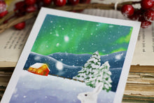 Lade das Bild in den Galerie-Viewer, Postkarte - Hase im Schnee - Polarlichter - Berglandschaft mit Hütte - warm and cozy holiday - Weihnachten Winter - Eigene Illustration