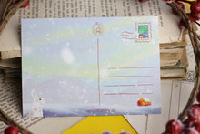 Lade das Bild in den Galerie-Viewer, Postkarte - Hase im Schnee - Polarlichter - Berglandschaft mit Hütte - warm and cozy holiday - Weihnachten Winter - Eigene Illustration