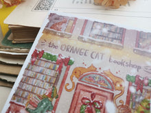 Lade das Bild in den Galerie-Viewer, Postkarte - Buchladen im Schnee - Weihnachten - orange cat bookshop - Aquarell - Cozy - Hund - Katze - Bücher - Eigene Illustration