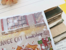 Lade das Bild in den Galerie-Viewer, Postkarte - Buchladen im Schnee - Weihnachten - orange cat bookshop - Aquarell - Cozy - Hund - Katze - Bücher - Eigene Illustration