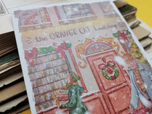 Lade das Bild in den Galerie-Viewer, Postkarte - Buchladen im Schnee - Weihnachten - orange cat bookshop - Aquarell - Cozy - Hund - Katze - Bücher - Eigene Illustration